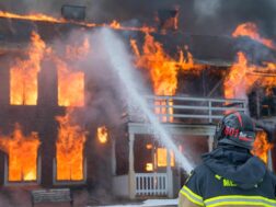 Firefighter putting out fire. National Fire Prevention Month