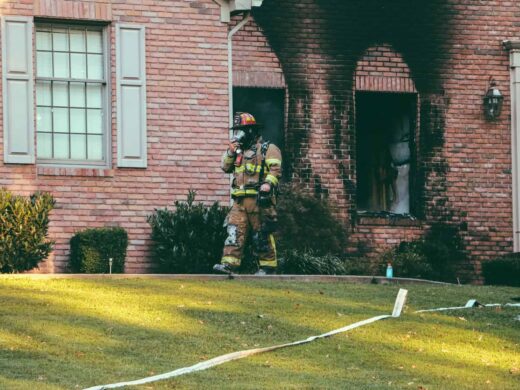 Fireman walking in front of brown brick house