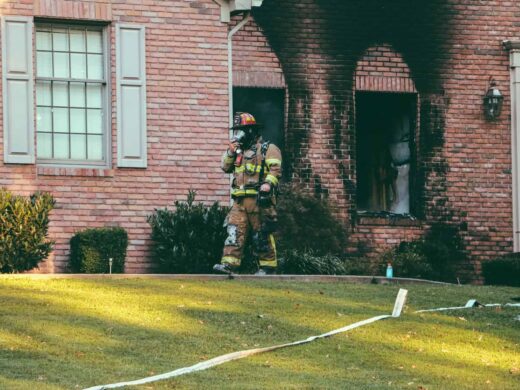 Fireman walking in front of brown brick house